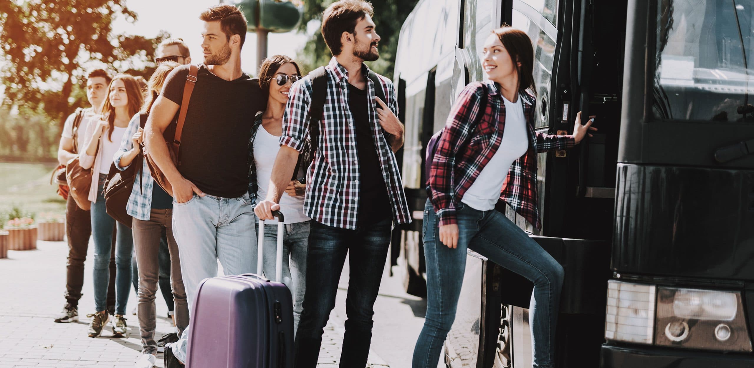 Gruppenreisen Personen mit Koffern am Bus